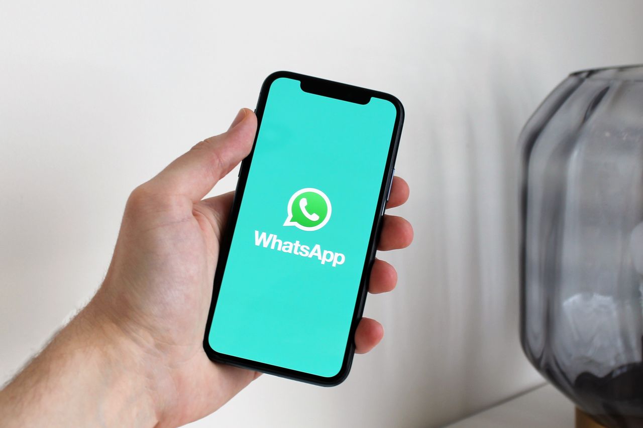 The Art of Drawing Readers In: Your attractive post title goes here Close-up of a hand holding a smartphone displaying the WhatsApp app screen.